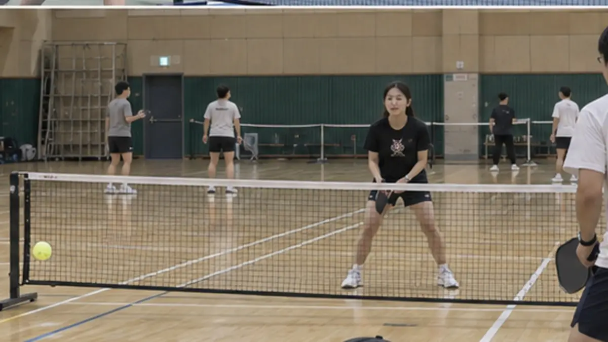 大学体育館のバドミントンコートで練習する学生クラブ
