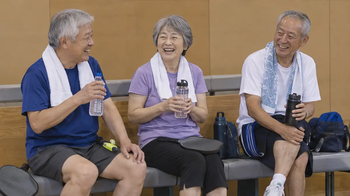 ベンチで水分補給しながら談笑するシニア仲間