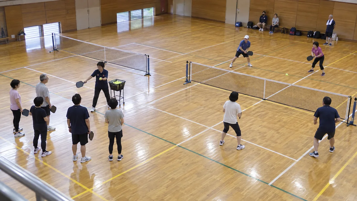 市民体育館で基礎練習とゲーム会を少人数に分けて進める様子