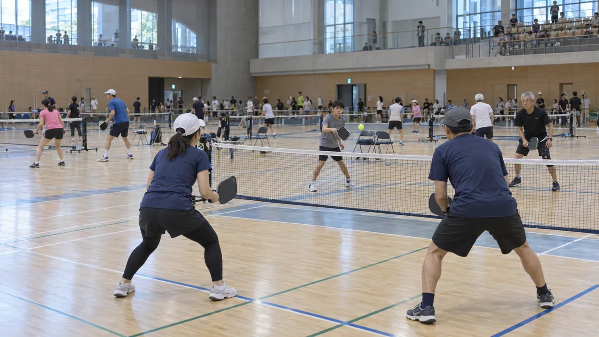 大規模な屋内会場で世代を超えてダブルスを戦う選手